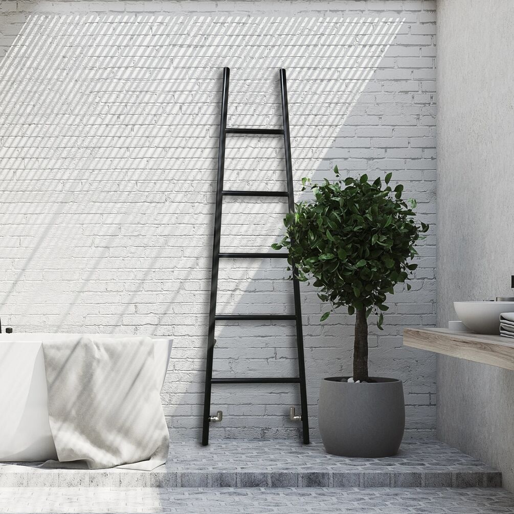Lifestyle image of the The Sussex Range by JIS Rye 1800mm x 520mm Black Heated Leaning Towel Rail installed against a wall, next to a white bathtub